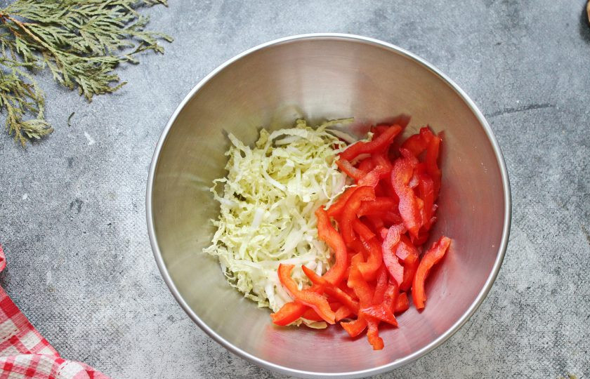 1. Этап. Салат с семгой и перцем: Листья пекинской капусты разрежьте вдоль на две части и порежьте соломкой. Болгарский перец разрежьте на четыре части и порежьте тонкой соломкой. Выложите овощи в салатник.
