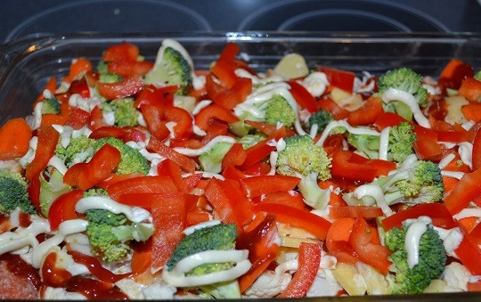 1. Этап. Красная рыба с овощами в духовке: 10. Ровным слоем выложите брокколи и сладкий перец. Добавьте немного майонеза.