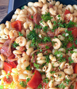 1. Этап. Быстрая сковорода Паста с чоризо: Высыпать в сковороду готовую пасту, добавить нарезанную петрушку, хорошо перемешать и выключить плиту.