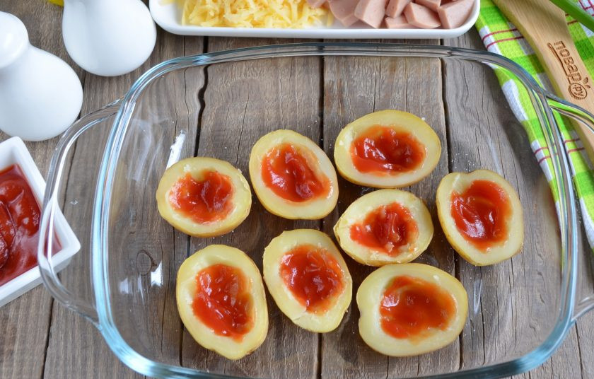 1. Этап. Пицца в картофельных лодочках: Щедро смажьте томатным соусом картофельные лодочки.