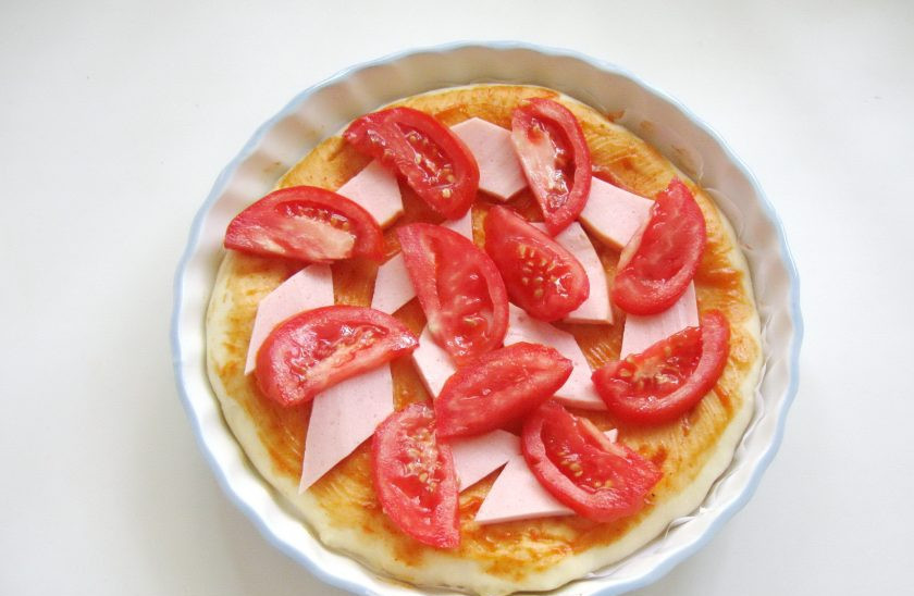 1. Этап. Пицца с колбасой и болгарским перцем: Помидоры нарежьте дольками и выложите на колбасу.