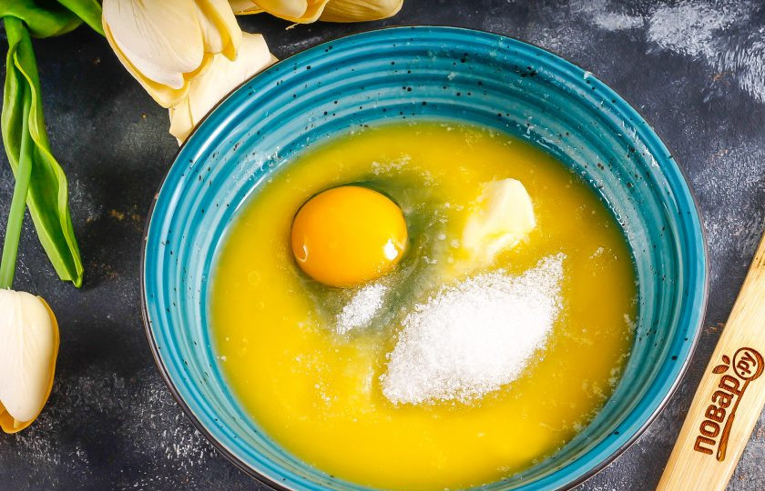 1. Этап. Песочное тесто с яйцами: Всыпьте в масло соль, сахар, вбейте куриное яйцо, тщательно вмешайте. Затем выложите еще желток. Белок добавлять не нужно, иначе тесто получится пористым, при выпекании оно сильно вздуется. Если вы хотите создать ровную основу, то можно просто добавить только желтки.