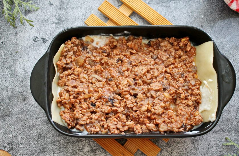 1. Этап. Мясная лазанья с грибами и соусом Бешамель: Смажьте его соусом и разложите сверху часть готового фарша, смажьте снова соусом. Повторите слои несколько раз.