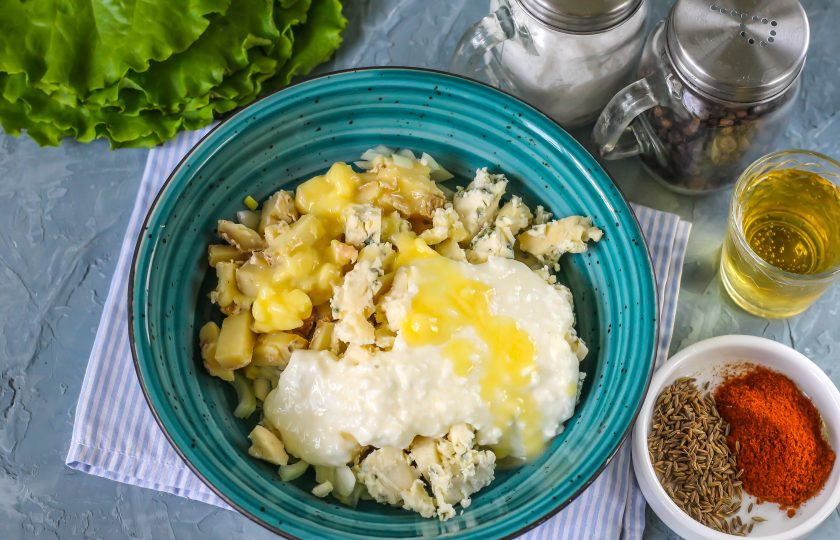 1. Этап. Обацда: Нарежьте сыр мелкими кубиками. Используйте и зрелый камамбер с плесенью, если такие продукты есть у вас в наличии. Выложите нарезку в емкость к луку. Добавьте туда же сливочный сыр. Растопите сливочное масло и влейте в емкость.