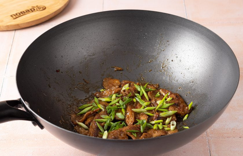 1. Этап. Соевое мясо в воке: Затем добавьте нарезанный зеленый лук. Перемешайте и снимайте с плиты.