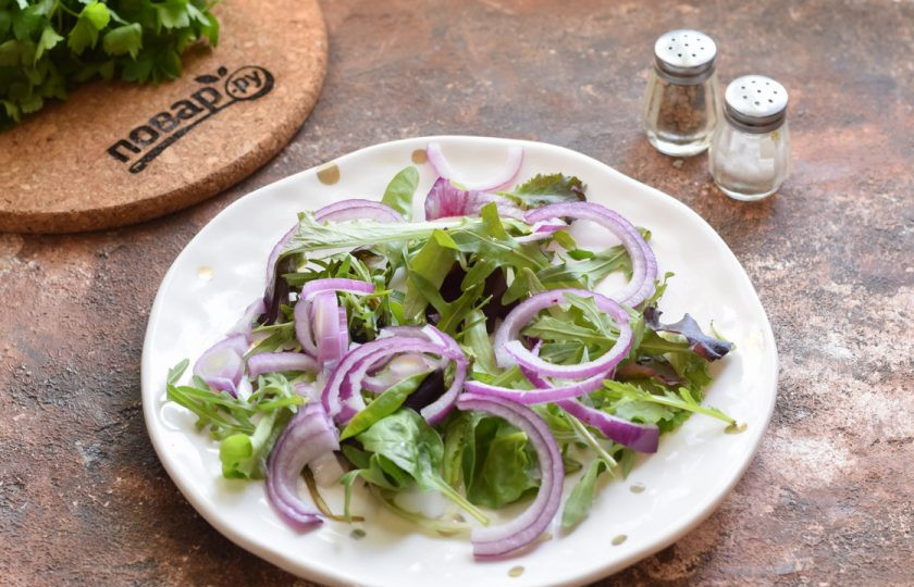 1. Этап. Салат из гребешков с рукколой: Сладкий синий лук ополосните и просушите, нарежьте тонкими полукольцами и добавьте в салат.