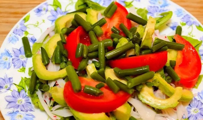 1. Этап. Салат из крабового мяса: 3. Авокадо очищаю и нарезаю ломтиками, томаты мою и нарезаю дольками, а спаржевую фасоль отвариваю немного. Выкладываю ингредиенты на салат: сперва крабовое мясо, затем авокадо, помидоры и фасоль.