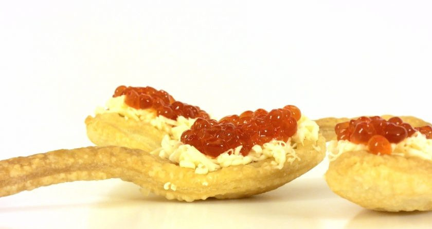 1. Этап. Слоеные ложки с красной икрой: 4. Замороженное масло натрите на мелкой терке и выложите на ложки из теста. Посыпьте икрой. Украсьте сервировочное блюдо салфеткой и выложите на нее слоеные ложки. Приятного аппетита!