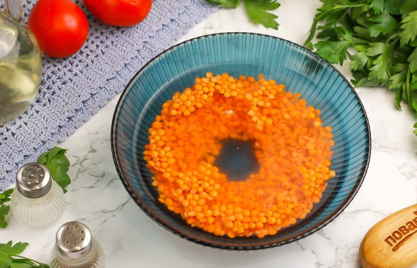 1. Этап. Чечевичный суп с курицей: Высыпьте чечевицу в глубокую емкость и залейте холодной водой. Промойте несколько раз, меняя воду по мере замутнения, пока она не станет чистой. Всыпьте чечевицу в кастрюлю и отварите суп еще 10-15 минут до разваривания бобовых.