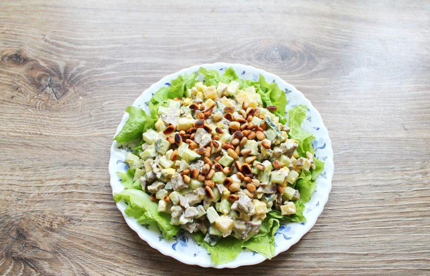 1. Этап. Салат с языком и кедровыми орешками: Остудите их и посыпьте верх салата.