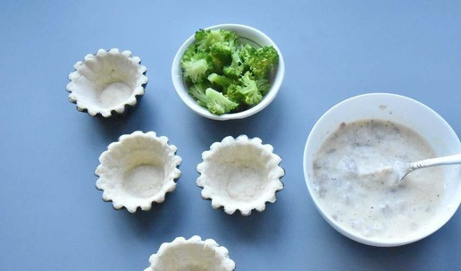 1. Этап. Мини пироги с тунцом и брокколи: Брокколи разбираю на соцветия и отвариваю в подсоленной воде в течение 2-3 минут. Откидываю брокколи на сито для удаления лишней влаги. В миске соединяю сливки, яйцо, сыр фета и растираю смесь вилкой. Добавляю измельченный тунец, перец черный молотый и по щепотке орегано и тимьяна.