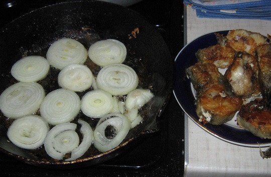 1. Этап. Минтай жареный с луком: 4. Далее возможно два варианта приготовления этого блюда. Лук можно добавить на сковороду к рыбе и жарить их вместе. Однако в данном случае предлагаю поступить немного иначе. Чтобы лук хорошо прожарился, но при этом пропитался соками рыбы, его необходимо обжарить отдельно, однако на той же сковороде, где жарилась рыба. Когда лук станет золотистым, можно вернуть рыбу на сковороду и обжарить все вместе еще пару минут.