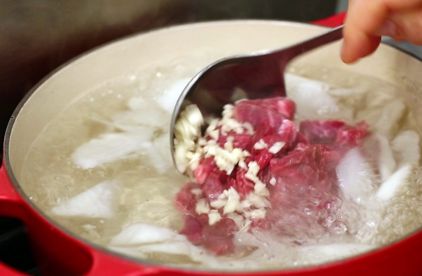 1. Этап. Суп на говядине: Говядину нарежьте мелкими кусочками и отправьте в дайкону вместе с измельченным чесноком.