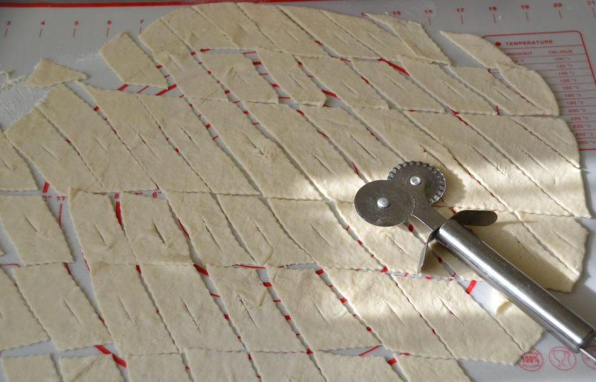 1. Этап. Хворост на пиве: Раскатайте тесто в тонкий пласт, нарежьте на полоски, в центре полоски сделайте прорезь.