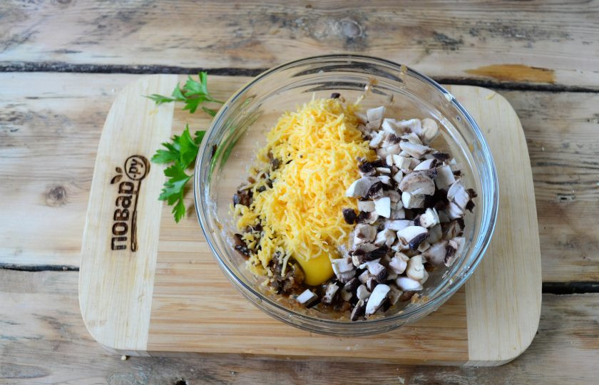 1. Этап. Котлеты из баклажанов с грибами: Шампиньоны очистите и порежьте на мелке кусочки, твердый сыр натрите на крупной терке. Смешайте грибы с сыром и баклажанами. Туда же отправьте яйцо, специи по вкусу (я кладу щепотку прованских трав). Хорошо перемешайте смесь и потом начинайте добавлять муку по 1 столовой ложке, вымешивайте массу и смотрите на консистенцию. В этот раз мне понадобилось чуть больше 3 ст. ложек муки, чтобы получить идеальную массу.