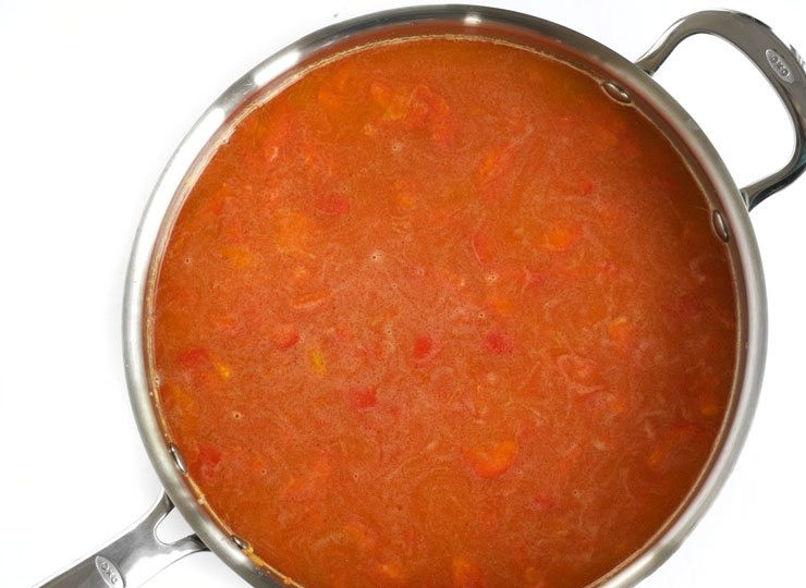 1. Этап. Рис с морепродуктами и овощами: 5. Влейте куриный бульон (можно овощной или воду). Накройте сковороду крышкой и после закипания тушите на слабом огне 15 минут.