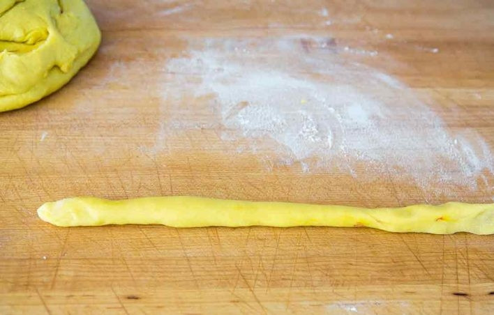 1. Этап. Булочки с шафраном: 9. Отделите небольшой кусочек теста и скатайте из него тоненькую колбаску.