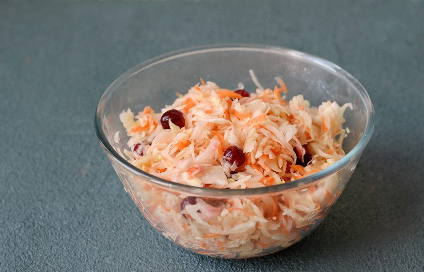 1. Этап. Квашеная капуста с клюквой и яблоками: Добавьте клюкву, перемешайте.