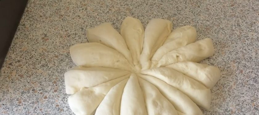 1. Этап. Шаньги на закваске: 4. Выложите тесто на присыпанную мукой поверхность, соберите края теста к середине и переверните. Разделите тесто на 14 частей, скатайте их в шарики и раскатайте в лепешки диаметром 20 см. Выложите лепешки на покрытый пергаментом противень.