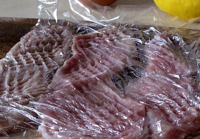 1. Этап. Телятина по-милански: Мясо выкладываем между пищевой пленкой и хорошенько отбиваем с двух сторон.