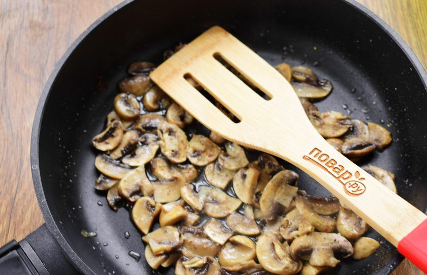 1. Этап. Салат Женская фантазия с курицей: Грибы нарежьте тонкими ломтиками, обжарьте на разогретом масле до румяной корочки.