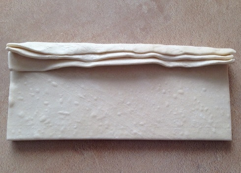 1. Этап. Чебуреки из слоеного теста: Тесто разморозилось, выкладываем три пластинки одна на другую и сворачиваем их.