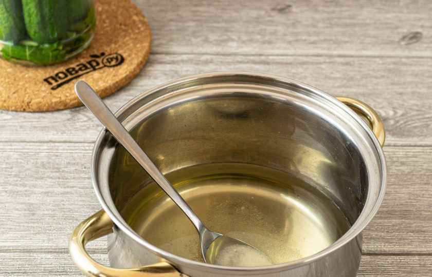 1. Этап. Огурцы на зиму с водкой: Аккуратно слейте воду в кастрюлю. Добавьте сахар и соль. Доведите до кипения. Проварите маринад 1-2 минуты.