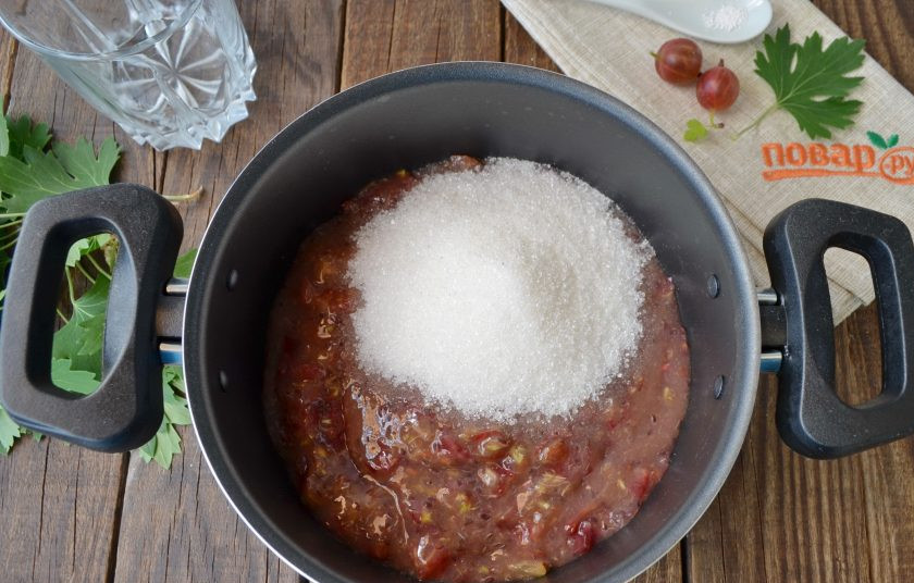 1. Этап. Варенье из крыжовника с листьями смородины: Перелейте крыжовниковую массу в кастрюльку, лучше антипригарную. Добавьте сахар, перемешайте деревянной лопаткой.