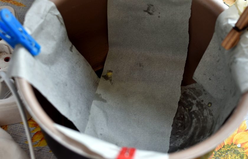 1. Этап. Наливной пирог с тунцом и помидорами в мультиварке: Для удобства вынимания готового пирога выложите чашу мультиварки лентами бумаги для выпечки крест-накрест, прихватив края прищепками, чтобы не сползали. Смажьте бумагу маслом.