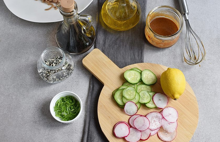 1. Этап. Гречневая лапша: Очень тонко нашинкуйте редис и огурец. Зеленый лук нарежьте наискосок.