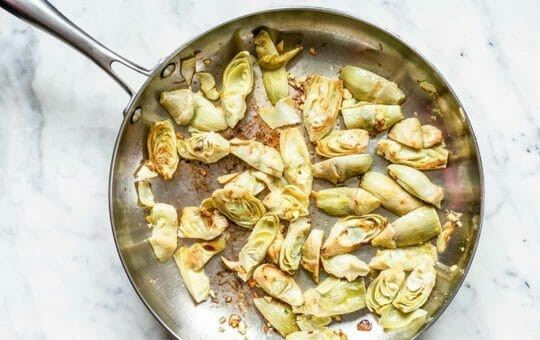 1. Этап. Паста с артишоками и шпинатом: 2. Тем временем отварите любые макароны по вашему вкусу и дайте им остыть. Пока они остывают, на раскаленную сковороду с маслом отправьте нарезанные пополам артишоки и жарьте их до золотистого цвета.