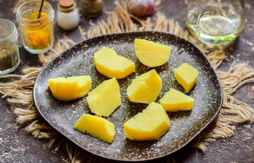 1. Этап. Салат из копченой рыбы с луком: Вареный картофель нарежьте крупно и разложите на тарелке.