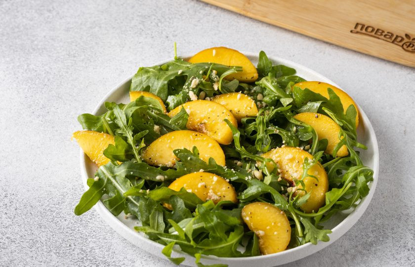 1. Этап. Салат с рукколой и персиками: Полейте салат заправкой и сверху присыпьте кедровыми орехами.