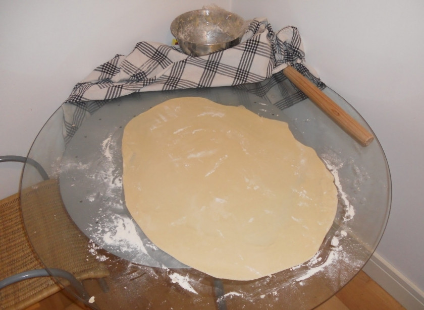 1. Этап. Булочки с корицей и изюмом: Посыпьте столешницу мукой и раскатайте на неё тесто, получится большой блин высотой и 0,5 см.