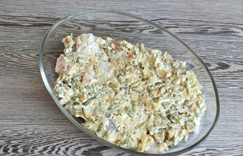 1. Этап. Треска запеченная с солеными огурцами: Огурцы с луком смешайте с майонезом. Полученную массу выложите на треску. Разровняйте. Влейте рассол. Поставьте в разогретую до 180 градусов духовку на 15 минут.