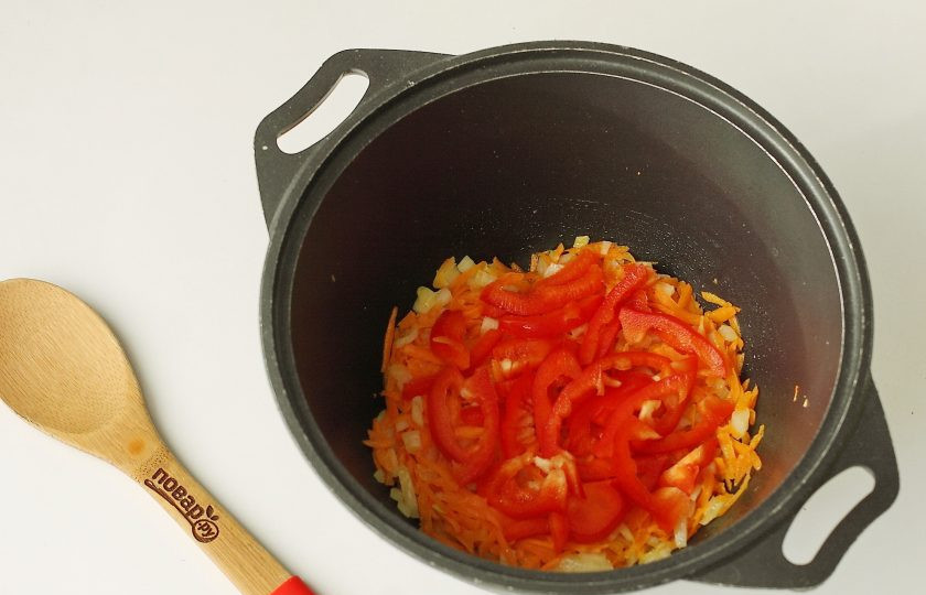 1. Этап. Пельмени в казане: Обжарьте овощи до мягкости, добавьте нарезанный небольшой соломкой болгарский перец.