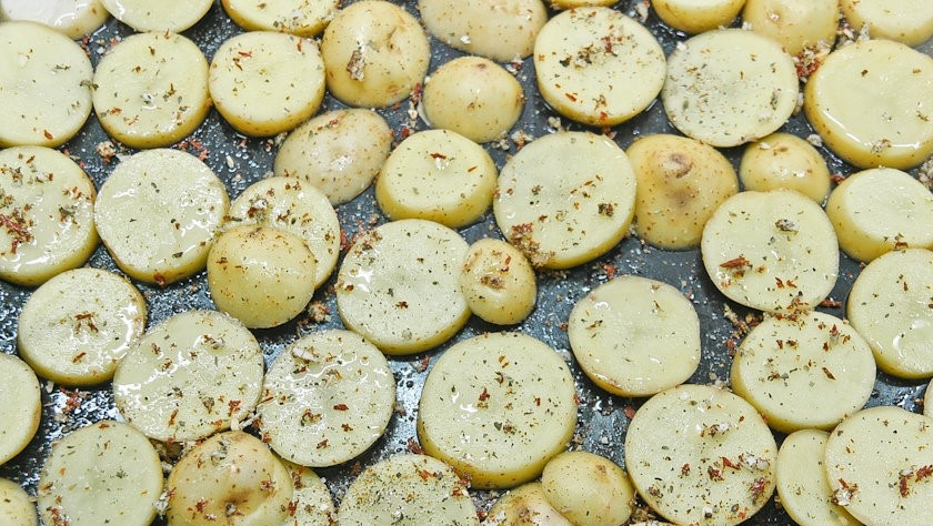 1. Этап. Слоеная картошка со свининой: 3. Разогрейте духовку до 220 градусов. На противень выложите кружочки картофеля. Сверху равномерно распределите часть чеснока. Посолите. Присыпьте любимой приправой. Слегка спрысните постным маслом. Отправьте в духовку. Запекайте 15 минут.