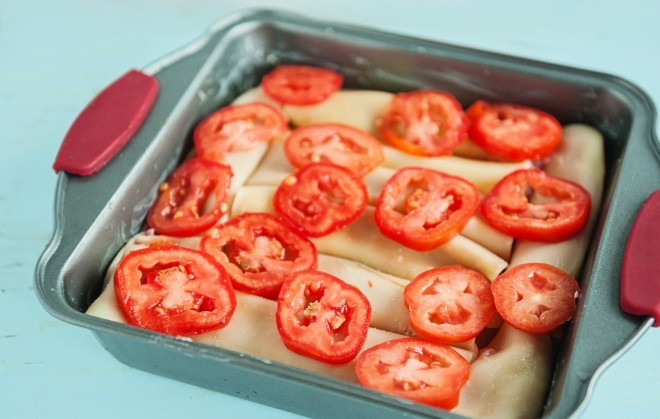 1. Этап. Каннеллони с куриным фаршем: Каннеллони отварите до полуготовности. Каждую макаронину набейте фаршем и выложите на смазанный маслом противень. Помидоры порежьте кружочками и выложите поверх макарон.