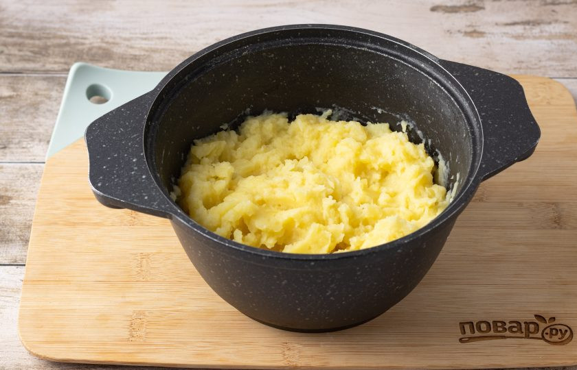 1. Этап. Картофельная запеканка с сосисками и грибами: С помощью толкушки измельчите картофель в пюре. Добавьте сливочное масло, молоко и соль по вкусу.