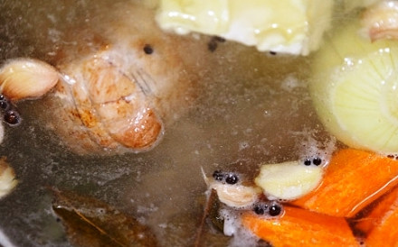 1. Этап. Солянка в мультиварке колбасная: 1. Чтобы начать приготовление самой солянки, сварим свиную косточку. Для этого промываем ее, выкладываем в кастрюлю и заливаем 2-мя литрами воды. Варим около часа, чтобы бульон был вкуснее и ароматнее добавляем очищенную морковь и луковицу, солим, добавляем лавровый лист и душистый перчик. Остужаем сваренную косточку, срезаем с нее мясо, а бульон процеживаем.