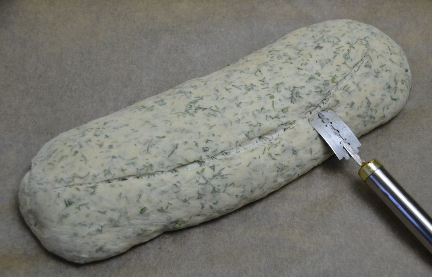 1. Этап. Хлеб с укропом: Через час прогрейте духовку до 220-240 градусов. На хлебе острым ножом или лезвием бритвы сделайте надрезы, можно сделать поперечные по диагонали или один большой надрез, как в этом рецепте. Выпекайте хлеб первые 10 минут при максимальной температуре, затем сбросьте жар на 180 градусов и выпекайте еще 40-50 минут до готовности.