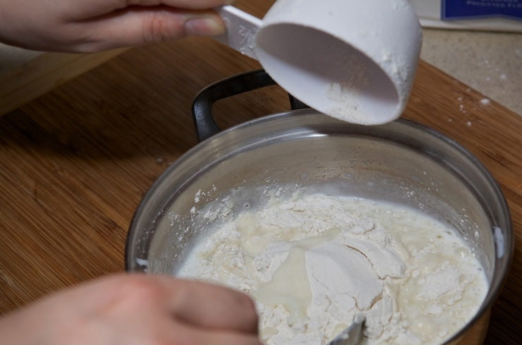 1. Этап. Заварное тесто для чебуреков с водкой: 2. Всыпьте грамм 100-120 муки, тщательно перемешайте, чтобы не образовались комочки.