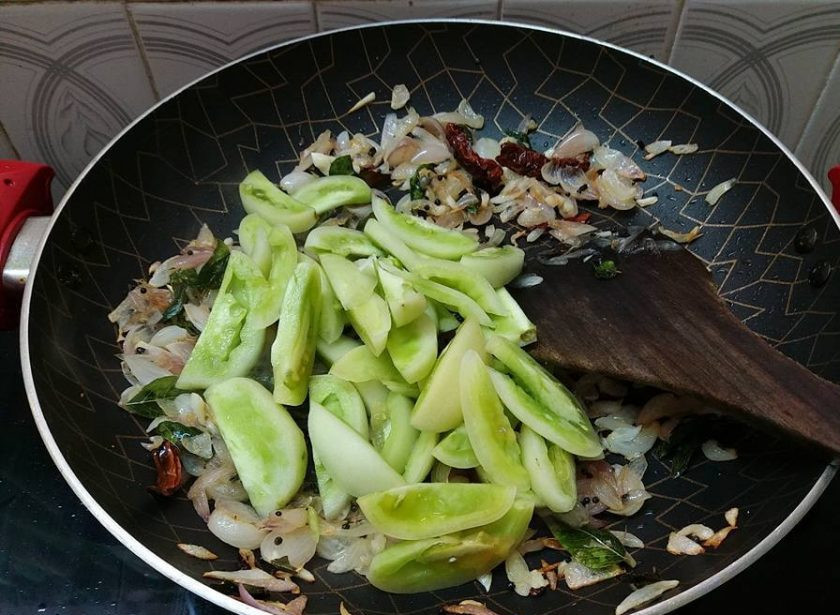 1. Этап. Бэби-кальмары с зелеными помидорами: 3. Добавьте зеленые помидоры и листья карри. Тушите овощи в течение 5 минут под закрытой крышкой на среднем огне.