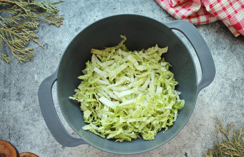 1. Этап. Салат с говяжьим языком и курицей: Пекинскую капусту разделите на листья, отрежьте места соединения, разрежьте вдоль на 2-3 полосы. Порежьте капусту соломкой и добавьте к языку.