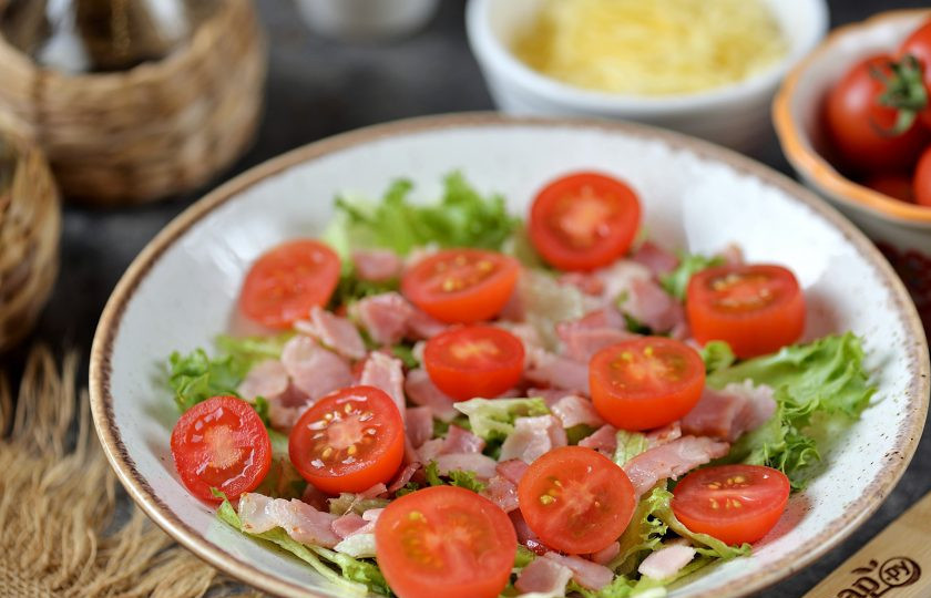 1. Этап. Салат Фризе с беконом: Помидоры черри нарежьте кружочками, выложите сверху на салат.
