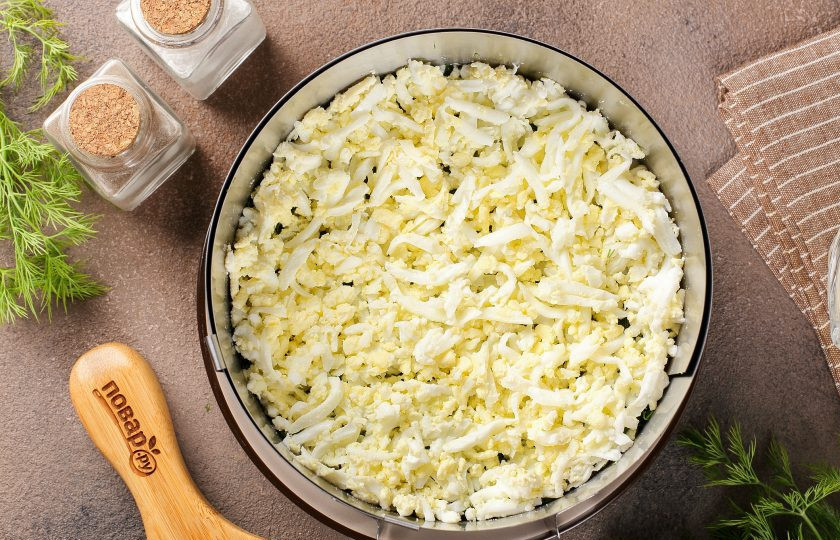 1. Этап. Салат Шпротка: Варёные яйца натрите на крупной тёрке. Половину яиц выложите следующим слоем. Посолите и смажьте майонезом.