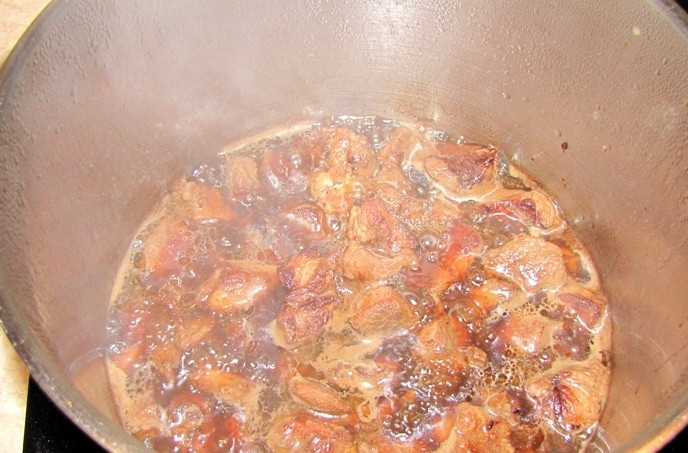 1. Этап. Соус из баранины с картошкой: Перекладываем обжаренное мясо в кастрюлю, а на сковороду наливаем пол стакана кипятка и при помощи деревянной лопатки растворяем в воде все оставшиеся после обжарки соки и так далее. Эту смесь переливаем в кастрюлю и добавляем в нее кипяток, всего жидкости должно быть около 1 литра. Тушим баранину в течение 15-20 минут на медленном огне.