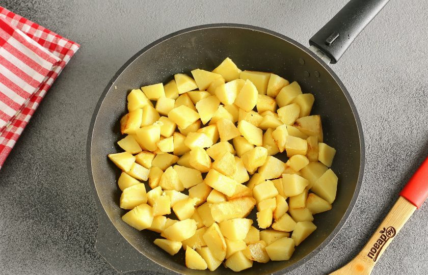1. Этап. Немецкий гуляш: Тем временем в сковороде обжарьте нарезанный небольшими кубиками картофель. Доводить картофель до полной готовности не надо, достаточно того, что появится зажаренная корочка средней плотности. В дальнейшем она не даст картофелю развариться в процессе приготовления.