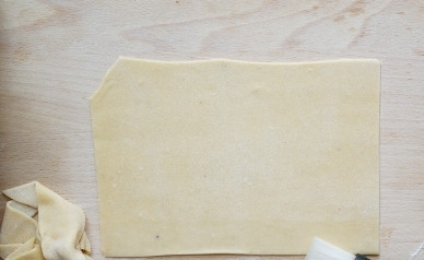 1. Этап. Постные равиоли: Нарезаем прямоугольные листы из раскатанного пласта (размером 9 на 6 см.). Смазываем один край листа водой, так тесто лучше скрепится.