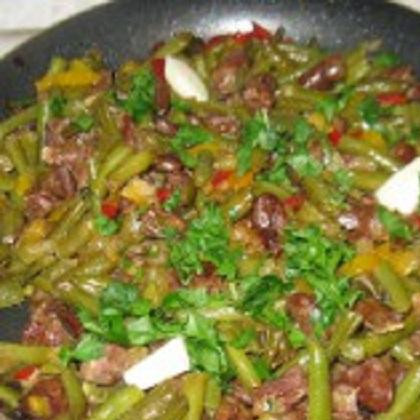 1. Этап. Куриные сердечки с фасолью: 3. Лук почистить и нарезать мелкими кусочками. Из перца удалить сердцевину и разрезать на мелкие кубики. Нарезать фасоль длинными дольками. Зубчики чеснока разрезать на несколько частей. В сковородке с сердечками обжарить лук и добавить фасоль. В последнюю очередь добавить болгарский перец. Положить по вкусу соли и перца и тушить минут 5-6. Добавить в смесь чеснок, базилик и порубленную зелень петрушки. Перемешать и на маленьком огне тушить еще около 10 минут. Можно приготовить гарнир, а можно подать самостоятельно.